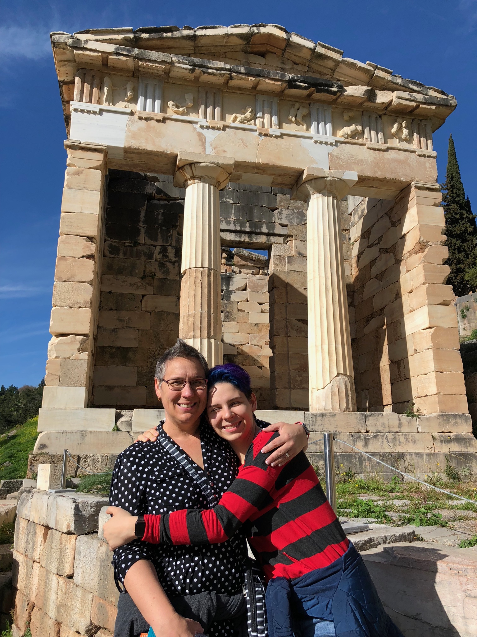 In front of the Temple of [they all start to run together]. Just kidding. It’s the Treasury of Athens at Delphi, built by the Athenians to give thanks for their victory at the Battle of Marathon. It used to be full of booty on display but you know how hard it is to keep booty around.