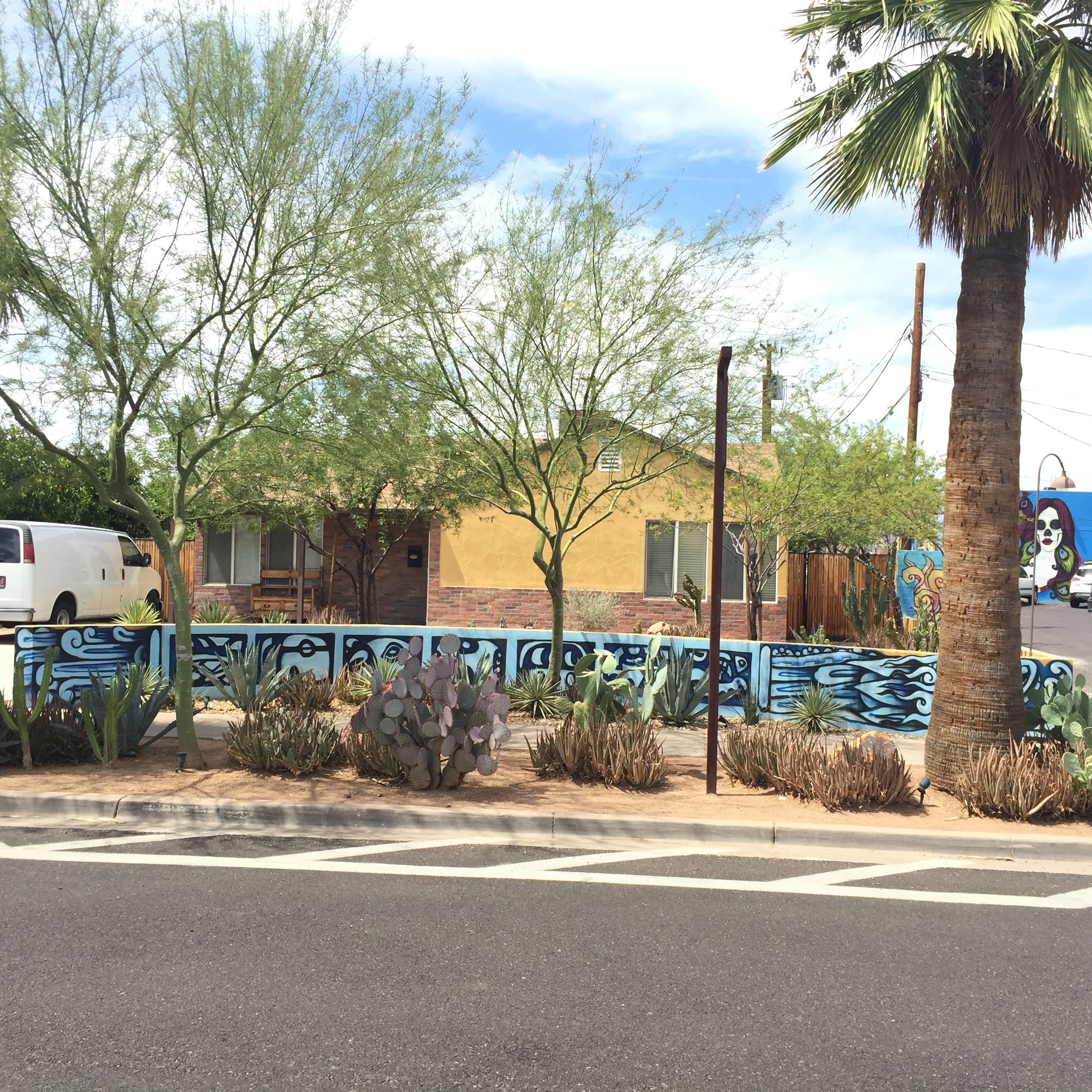 A wall along the sidewalk in the neighborhood area near the Barrio Cafe. You can see the previously-seen chica bonita on the blue wall in the background.