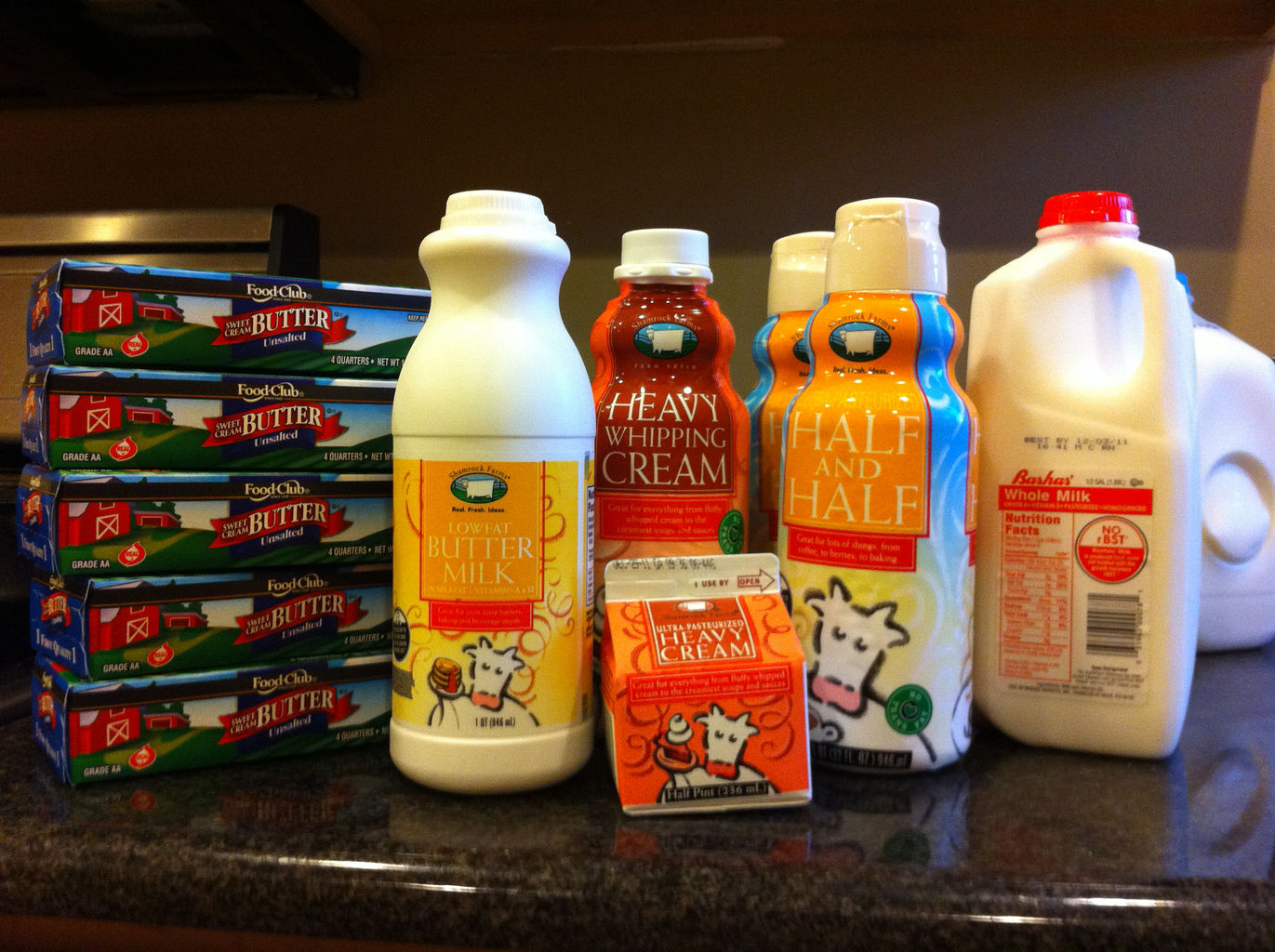 A photograph of groceries on the counter before being put away. The stash includes five punds of butter, buttermilk, half-and-half, and heavy cream, and whole milk.